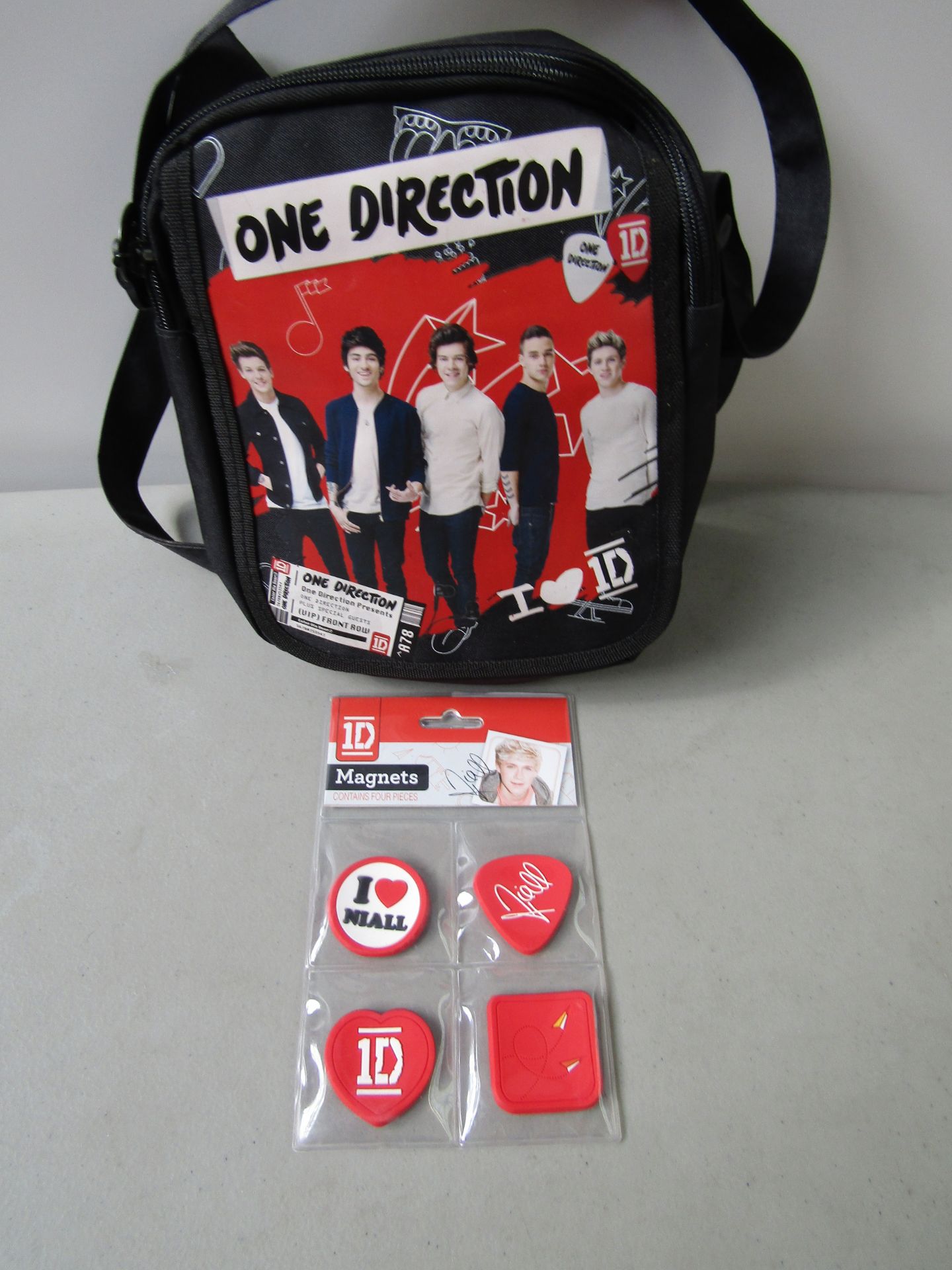 2x Items Being: 1x One Direction Small Satchel Bag 1x Pack of 4 One Direction Magnets