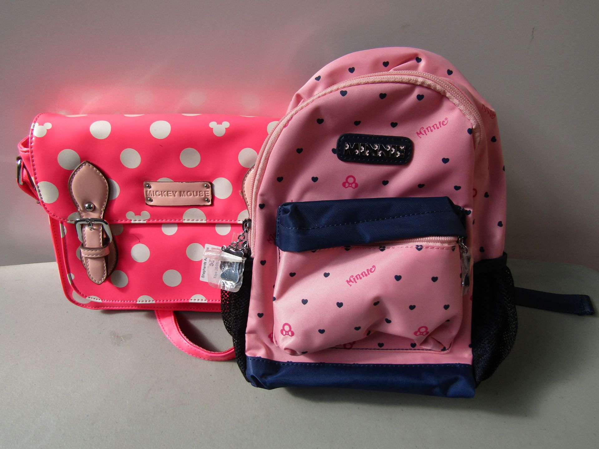 2x Items Being: - 1x Mickey Mouse Handbag - 1x Minnie Mouse Backpack