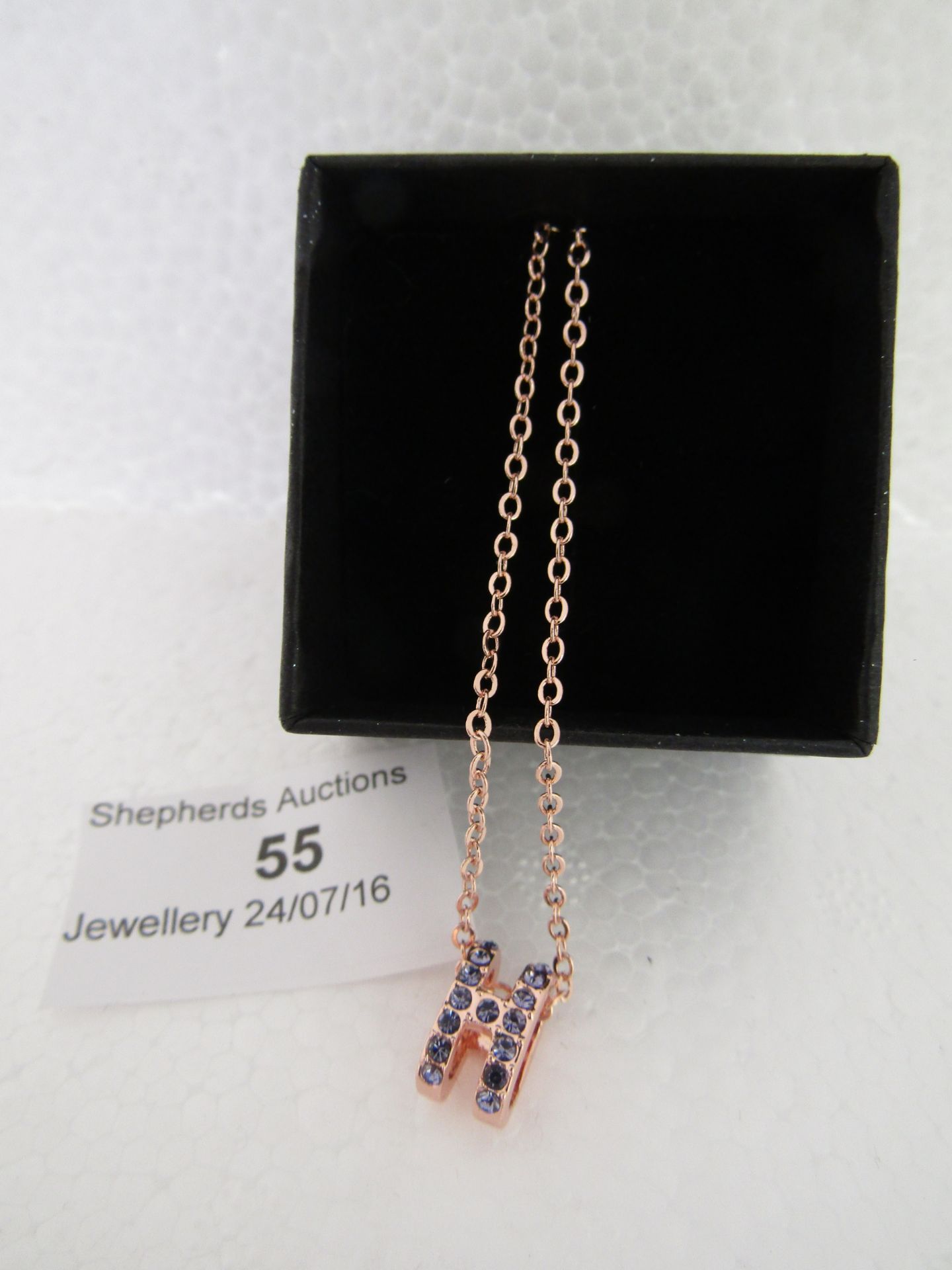 Fifth NYC Rose Gold Plated necklace which has a H pendant with Purple Czech rhinestones covering the