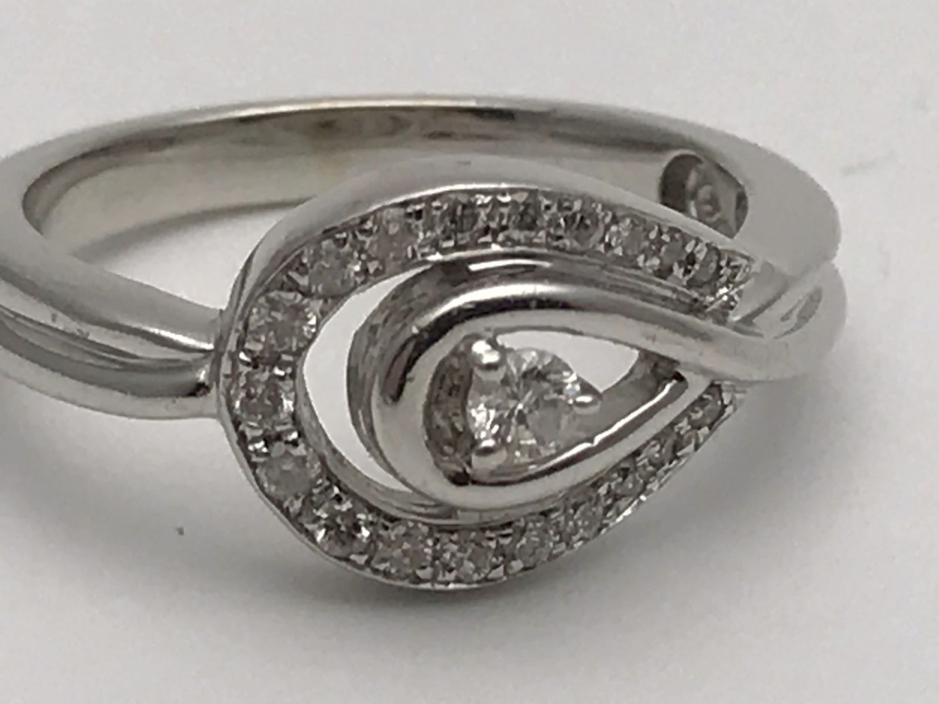 RRP £2500 A WHITE GOLD DIAMOND RING MADE TO FORM A LOOP & SET WITH HIGH QUALITY DIAMONDS GIVING