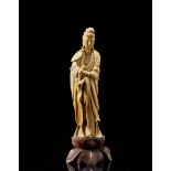 A soapstone model of a standing Guanyin wearing long robes and carryng a scroll, with base China,