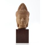 A grey stone head of a deity in Khmer style, with wood base (h. 18 cm.)