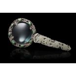 A magnifying glass composed by a celadon jade handle carved and pierced as a dragon, mounted on