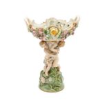 Alzata in ceramica decorata a motivi floreali in basso rilievo e con due putti che reggono la