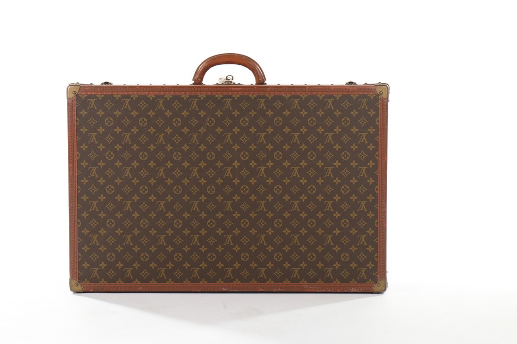 A Louis Vuitton monogrammed hard-sided suitcase, probably 1950s, with leather binding,