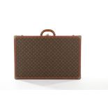 A Louis Vuitton monogrammed hard-sided suitcase, probably 1950s, with leather binding,