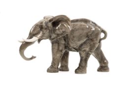 Schreitender Elefant Naturalistisch staffierte Figur eines Elefanten. Ungem. H.: 25 cm. Unter dem