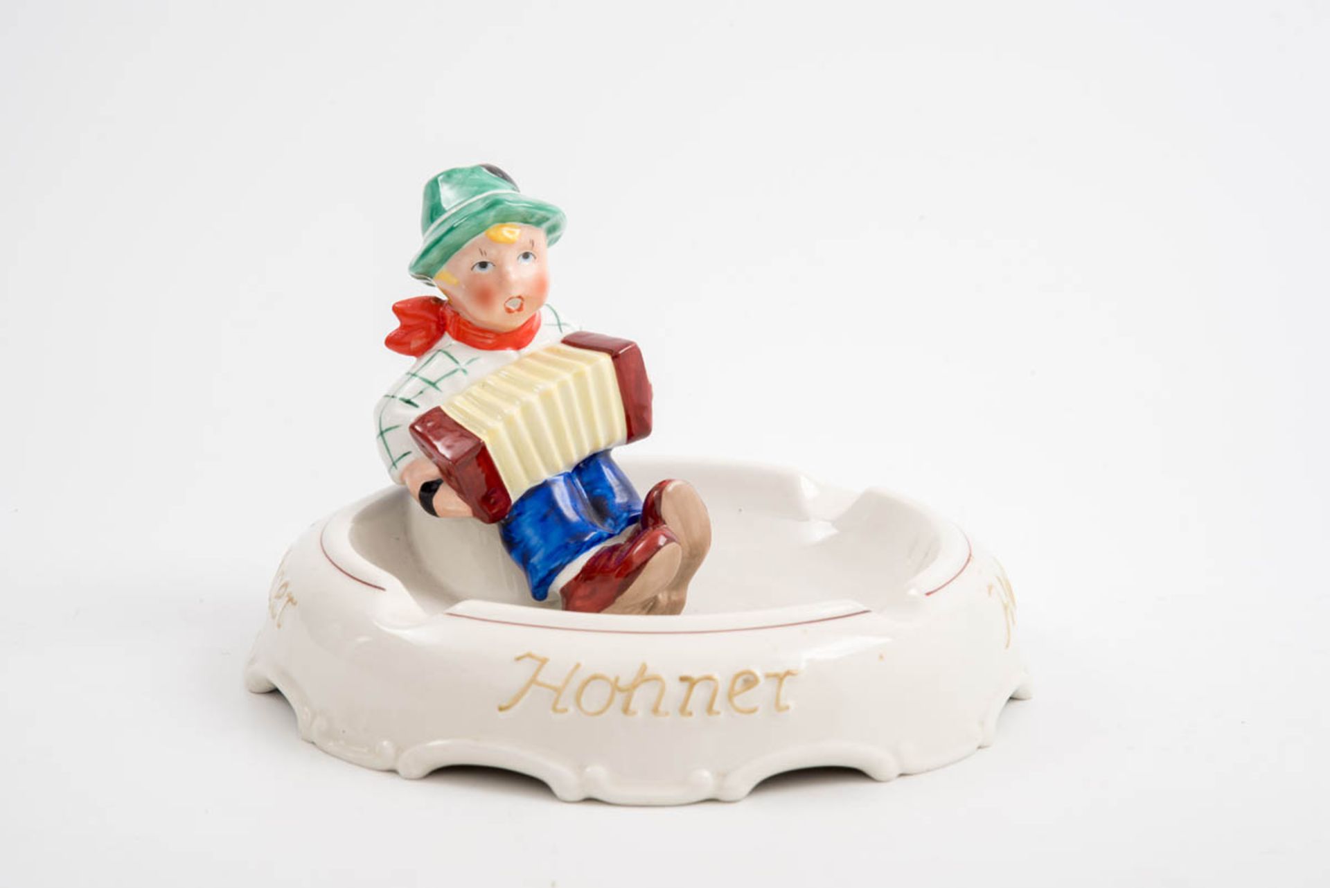Ascher "Hohner", Fischer & Co., Oeslau Flachgemuldete Form auf dem Rand aufsitzende Figur eines