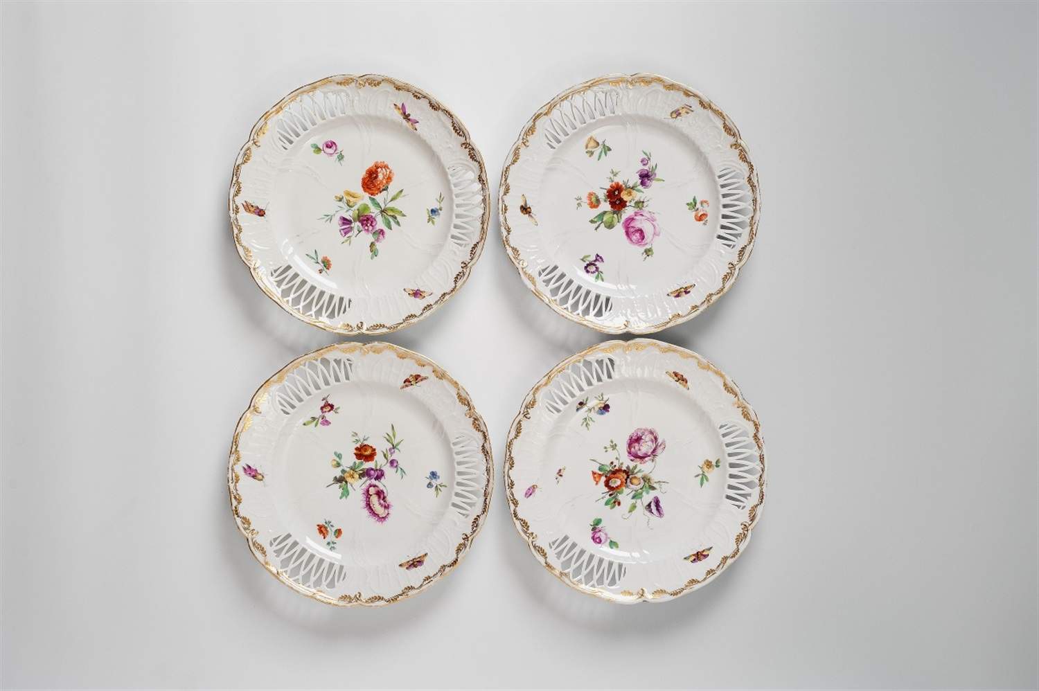 Four Berlin KPM porcelain dessert plates With an openwork border, decorated with bouquets and