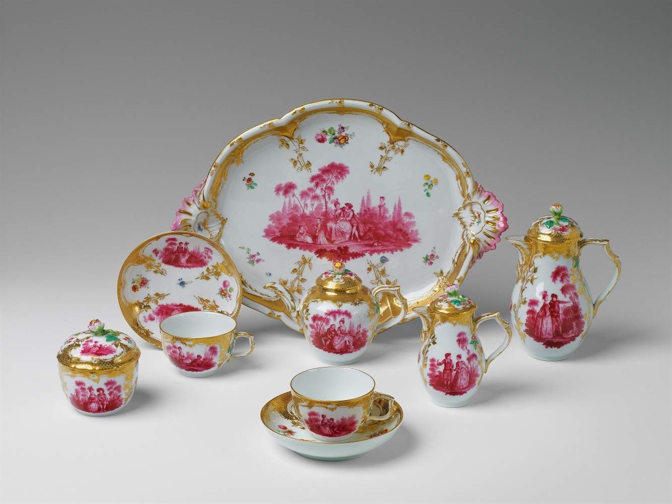 A Berlin KPM porcelain tête à tête with scenes after Watteau Comprising a tray, two cups and