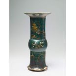 A large, green lacquered faience vase Decorated with buildings and figures in a river landscape. The