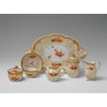 A Berlin KPM porcelain solitaire with scenes after Watteau Comprising a tray, milk jug, teapot,