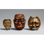 Drei Masken-Netsuke. Holz. 19. Jh. a) Okina-Maske. b) Große Beshimi-Maske. Bez.: Deme kore saku.