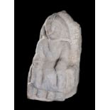 Sculpted stone relief depicting a seated figure. Circa 1400. 32 x 18 x 17 cm.