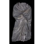 Incomplete stone sculpture of a saint covered with a draped tunic. Circa 1500. Cut off at the