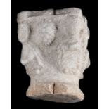 Sculpted stone capital depicting human figures on the corners, with bunches of grapes between them.