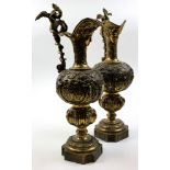 A pair of brass garniture jugs, decorated with winged Serpants to handle, 54cm high