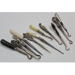 Seven small button hooks (5 with silver handles) and 4 manicure implements.