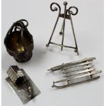 Four miniature unmarked silver items. Basket and easel, silver sledge marked 800 S S H and dog &