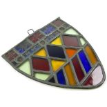 Stained glass window in the shape of a shield with various colours