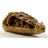 Japanese ivory netsuke depicting figures in a boat shaped like a serpent, length approx 5.5cm and