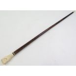 Malacca walking stick, circa early 20th century, with carved ivory (?) handle depicting a fist and
