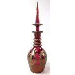 Large cranberry coloured glass decanter with stopper, ornate gilt decoration, possibly oriental,