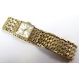 Ladies 9ct gold Longines wristwatch, square silvered dial with gilt batons. The gold bracelet with