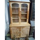 Stripped pine Cornish dresser, the arch glazed top enclosing three shelves over a cupboard base,