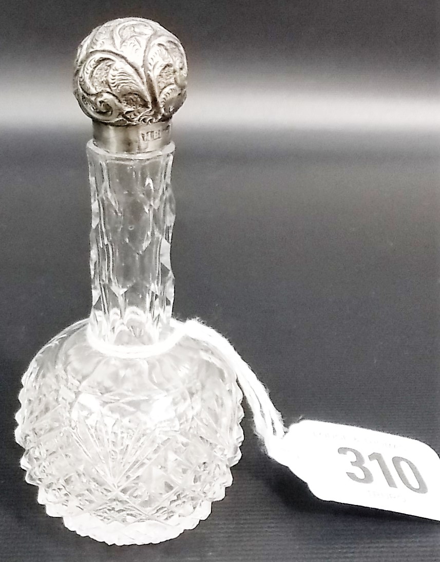 Small Victorian silver lid cut glass perfume bottle, the ovoid foliate embossed screw lid over an
