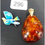 Clear amber large pendant with yellow metal suspension loop, the amber with plant inclusions, weight