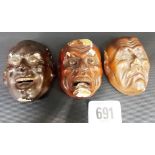 Three Japanese lacquer masks with inset glass eyes, height of each 2.5'