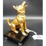 A gilt painted spelter model of a seated Alsatian upon black celluloid square plinth, height 4.25'