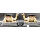 Pair of bronzed metal stands modelled as reclining camels upon an oval stepped base, width 10.25'