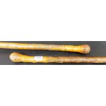 Two Oriental bamboo walking sticks each with carved figure and foliage decoration