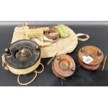 Three vintage fishing reels including a Bakelite Alcock Aerilite reel, within canvas bag with
