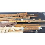 Six various vintage fishing rods within canvas bags.