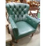 Victorian button back green leather upholstered armchair upon turned oak fore legs and brass