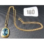9ct blue topaz set pendant, the oval cut stone within an oblong shaped mount and on a curb link fine