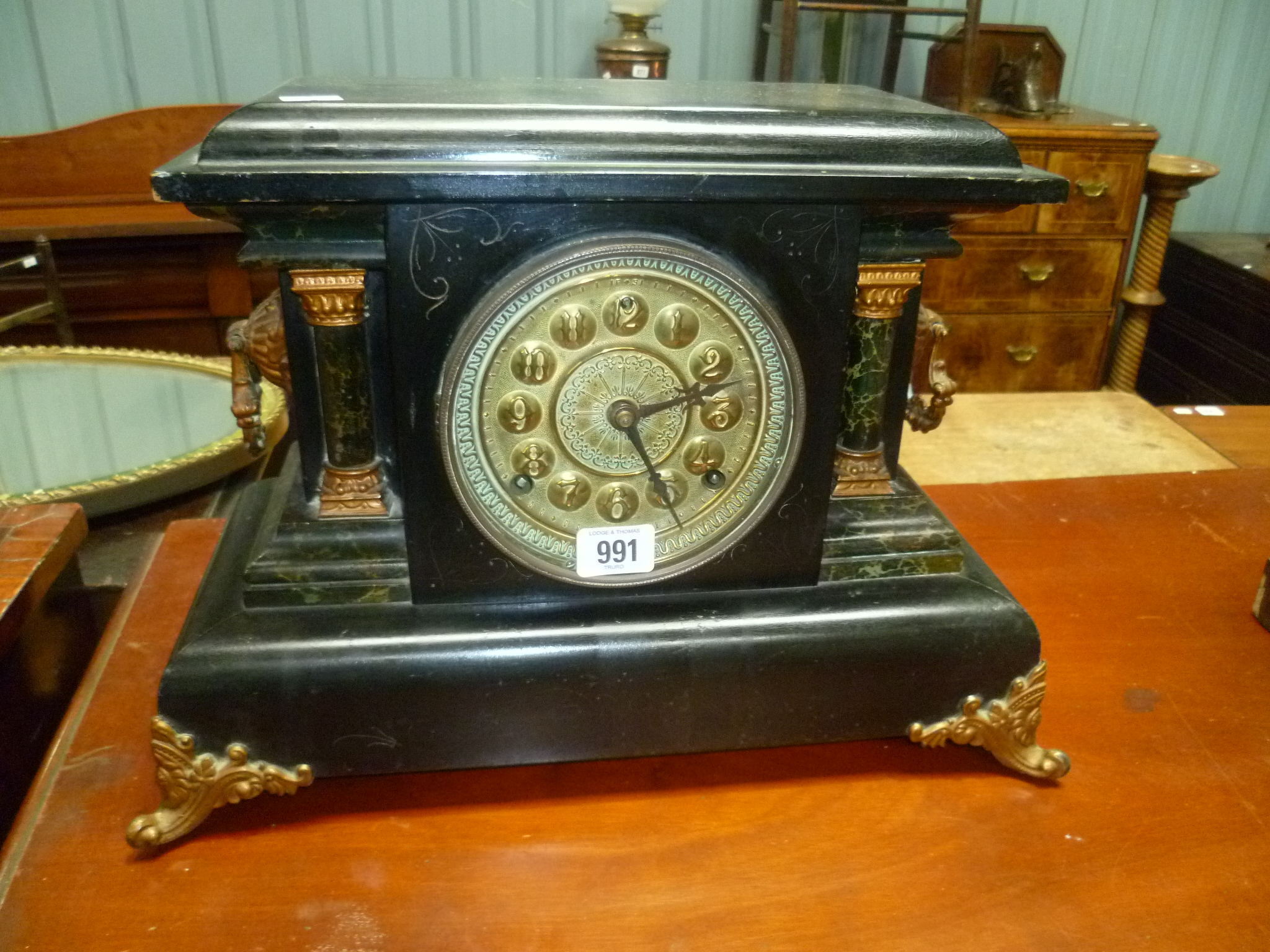 Black painted slate and marbel simulated three train mantle clock with 5' brass circular dial and