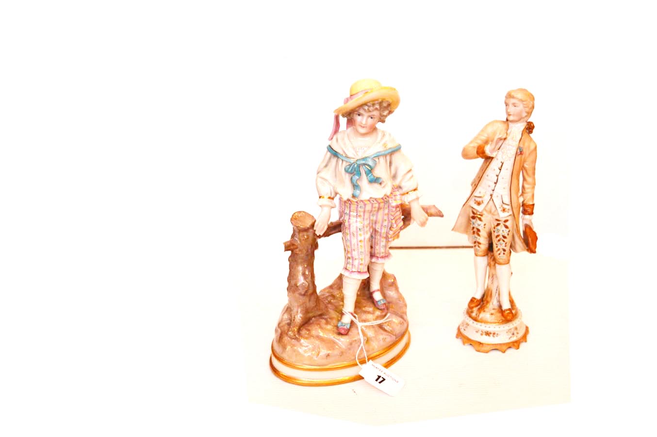 A Ceramic Figurine ‘Boy at Tree Stump’ and Another