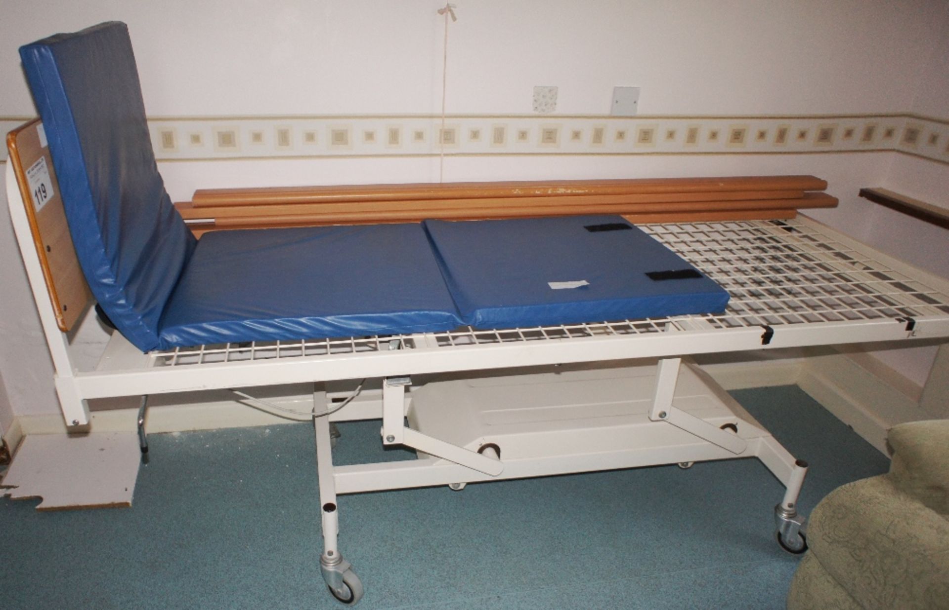 1 manually operated rise and fall patient bed with a foam filled floor mattress (located in room