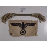 a WW2 German Army sport shirt eagle with Swastika in talons & 1 double ended tassel type object,