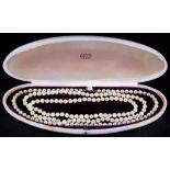 110 cm lange Perlenkette mit silberner Montur, diese mit großer Perle von Saphirsplittern umgeben.