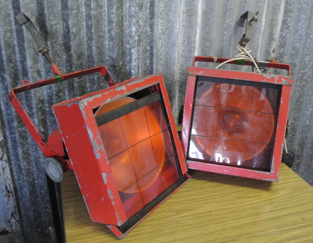 INDUSTRIAL/ LIGHTING - A pair of vintage metal theatre lights that have been painted orange.