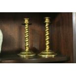 FURNIUTRE/ HOME - A pair of brass barley twist candlesticks, each measuring 18cm tall.