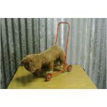 VINTAGE / TOY - A vintage children's stuffed dog on red metal trolley, in loved condition.