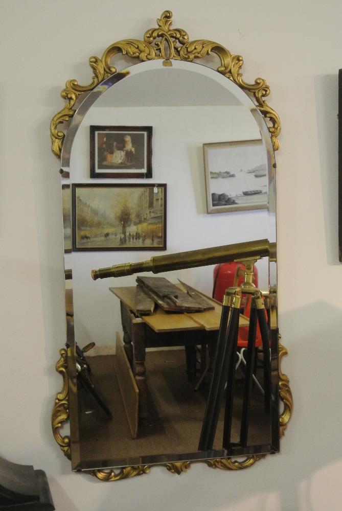 FURNITURE/ HOME - A vintage bevelled glass mirror in carved gold effect frame, measuring 38x82cm.