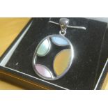 SILVER SHELL NECKLACE: A modern sterling silver oval pendant set with multi-coloured shell inlay.