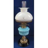 Early 20th Century brass double burner oil lamp with coloured glass moulded reservoir on brass